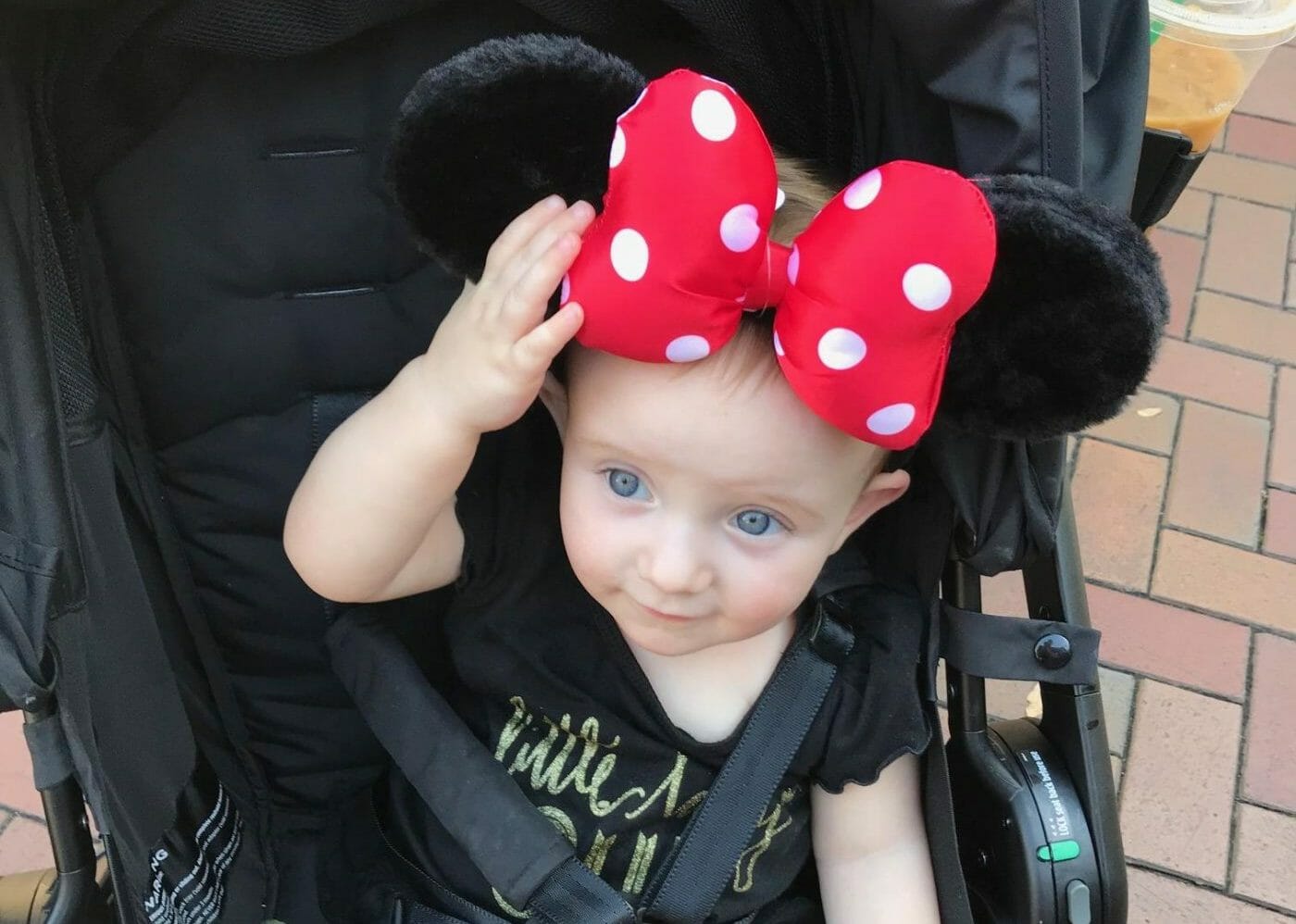 A baby sits in an Ergobaby stroller at Disneyland