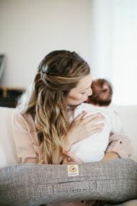 woman using Ergobaby Nursing pillow with baby