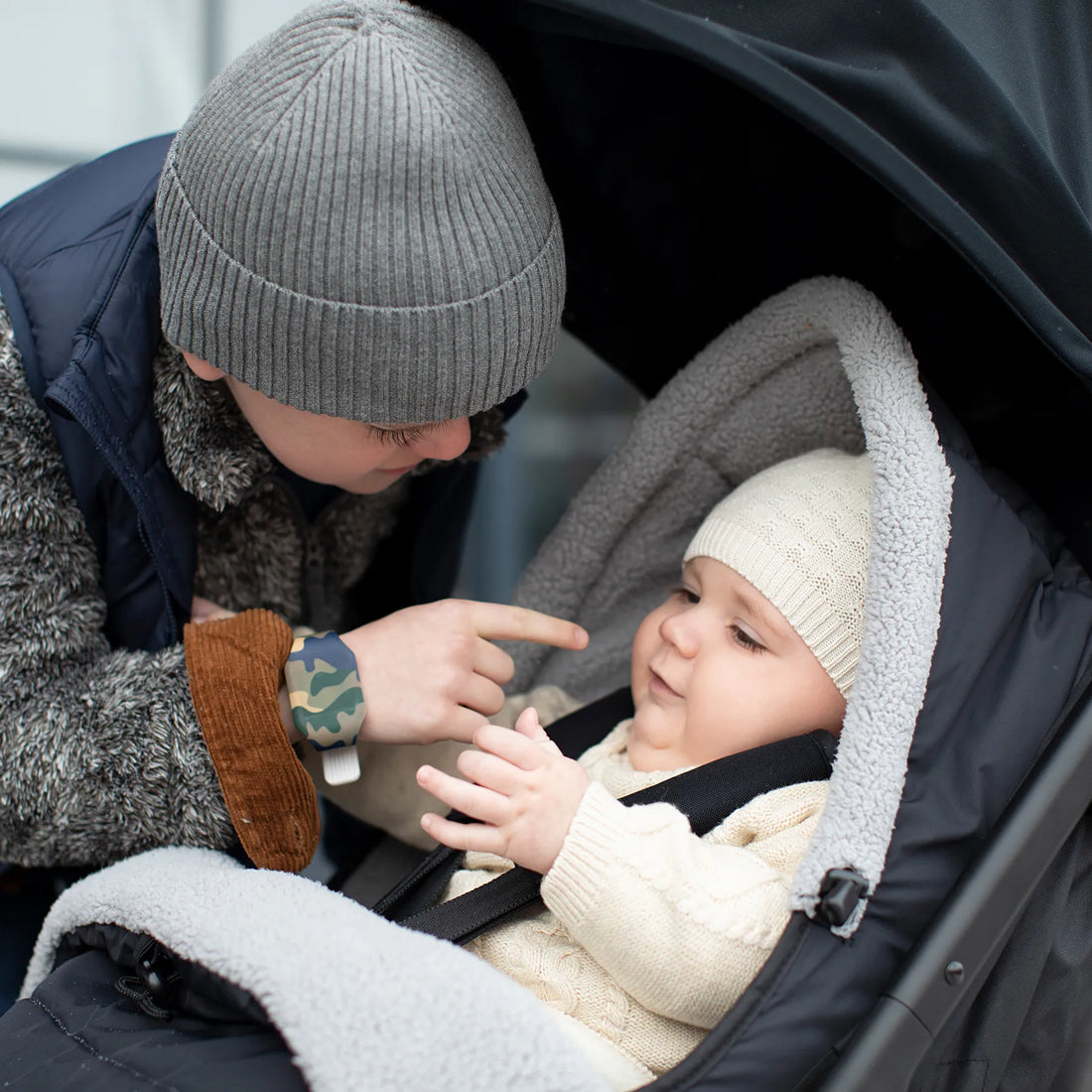 Kid playing with a baby in a stroller