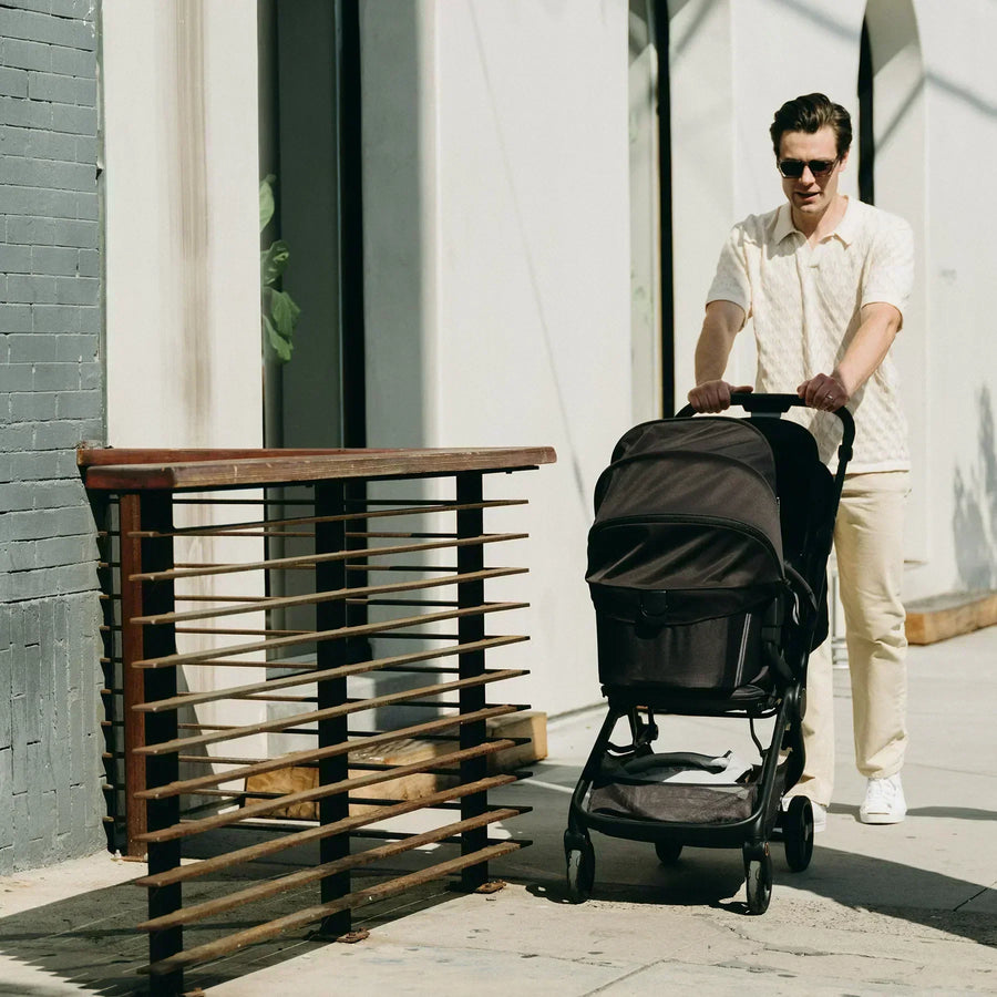 Man pushing stroller outside