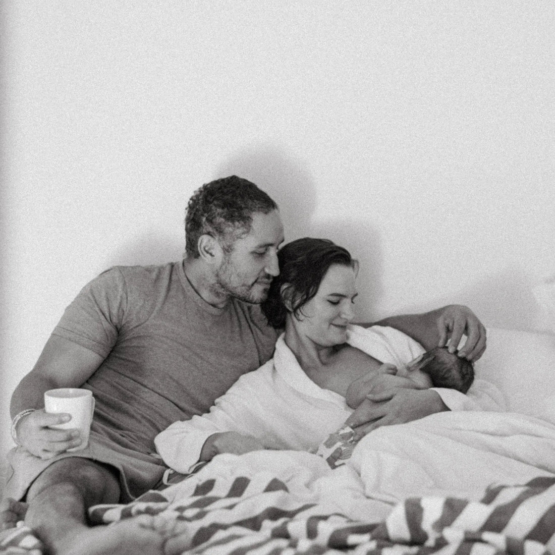 Man and woman in bed while woman breastfeeds