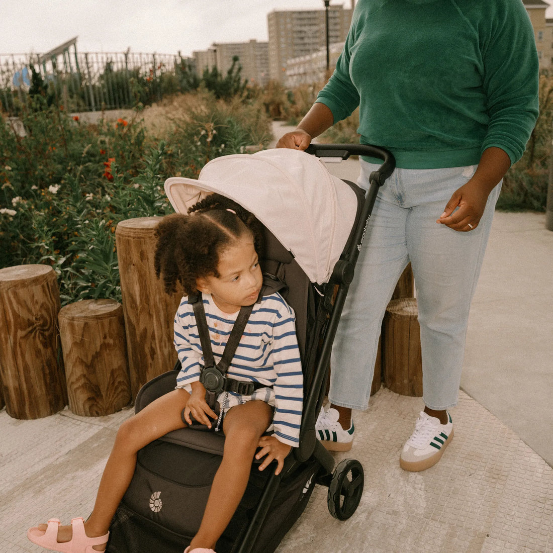 Woman pushing a baby in a stroller in a park
