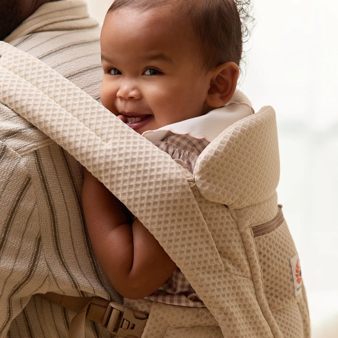 Baby in a beige woven baby carrier