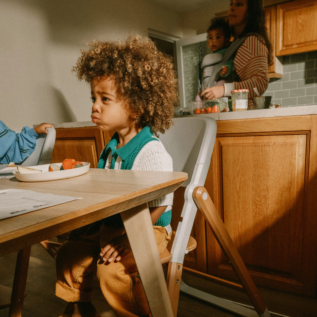 Toddler sitting in a high chair eating 