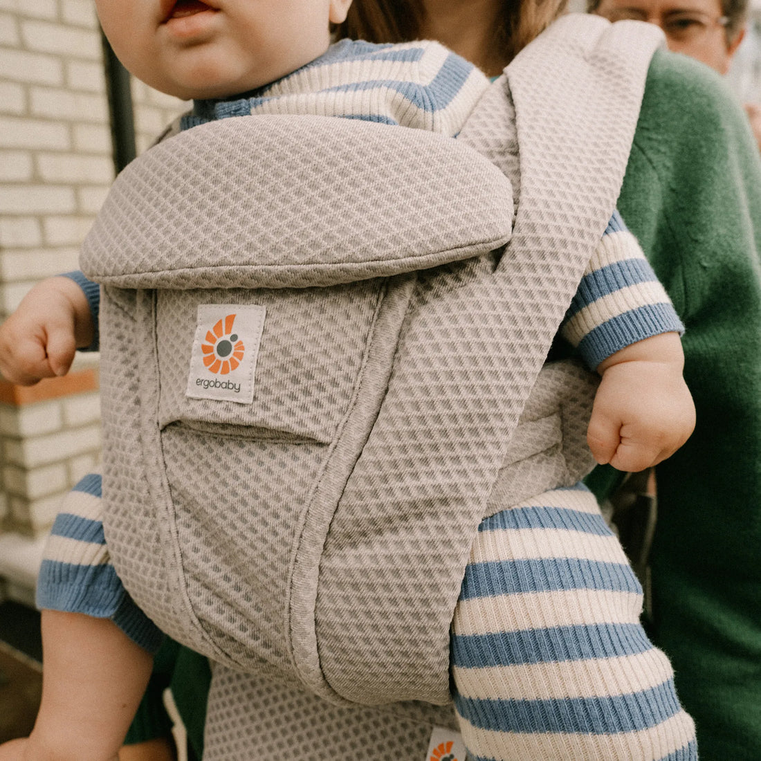 Baby in a grey baby carrier