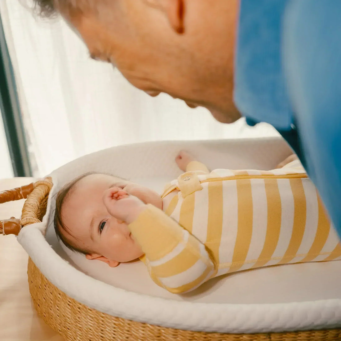 Baby laying in a crib looking up at a man