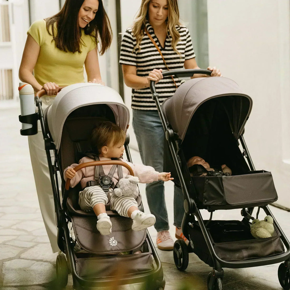 Two women pushing babies in strollers 