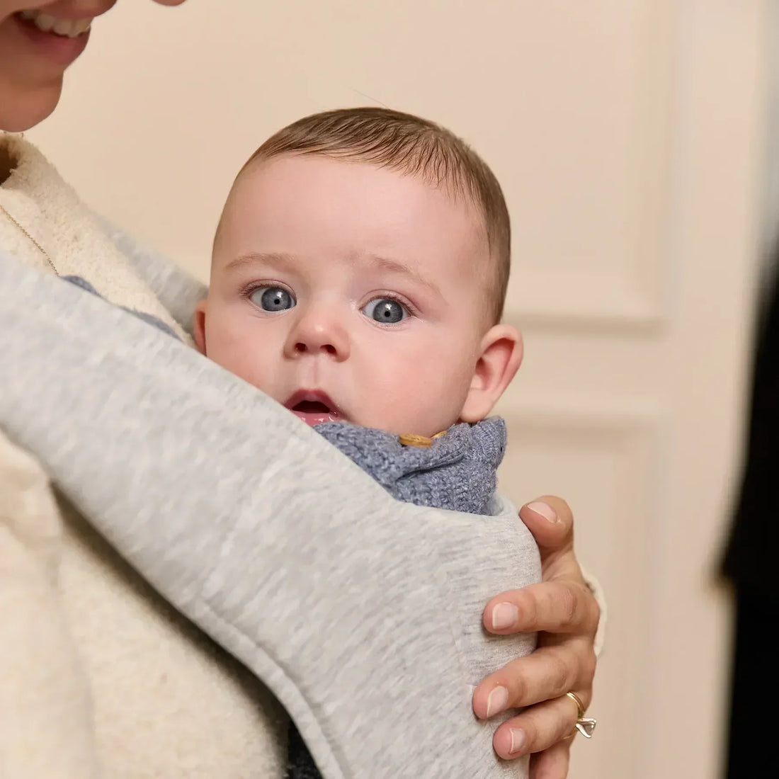 Baby in a light grey baby carrier