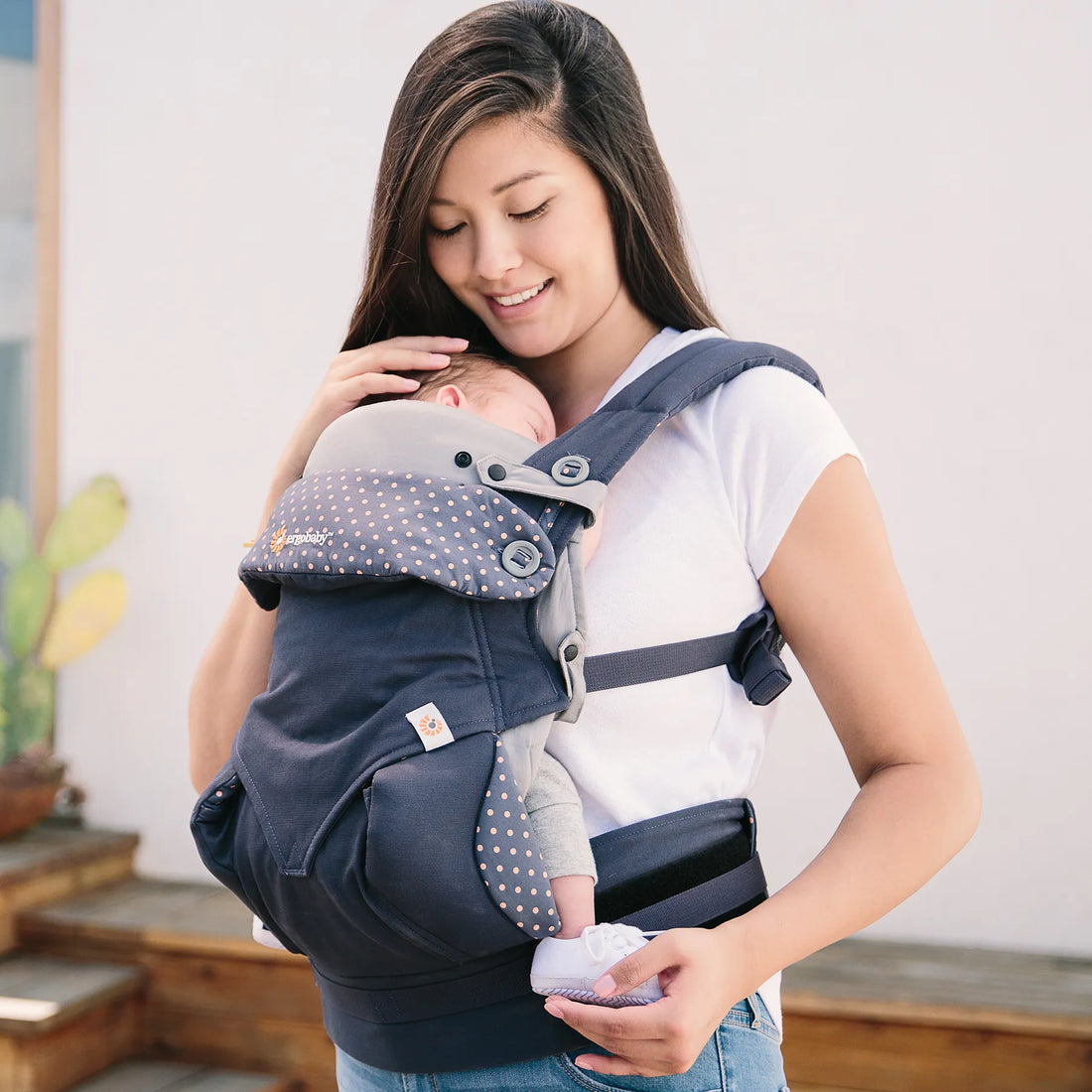 Woman holding a newborn baby in a baby carrier