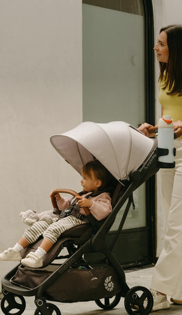 Child in a Metro 3 Deluxe stroller while her and her mom enjoy a beautiful stroll through town.
