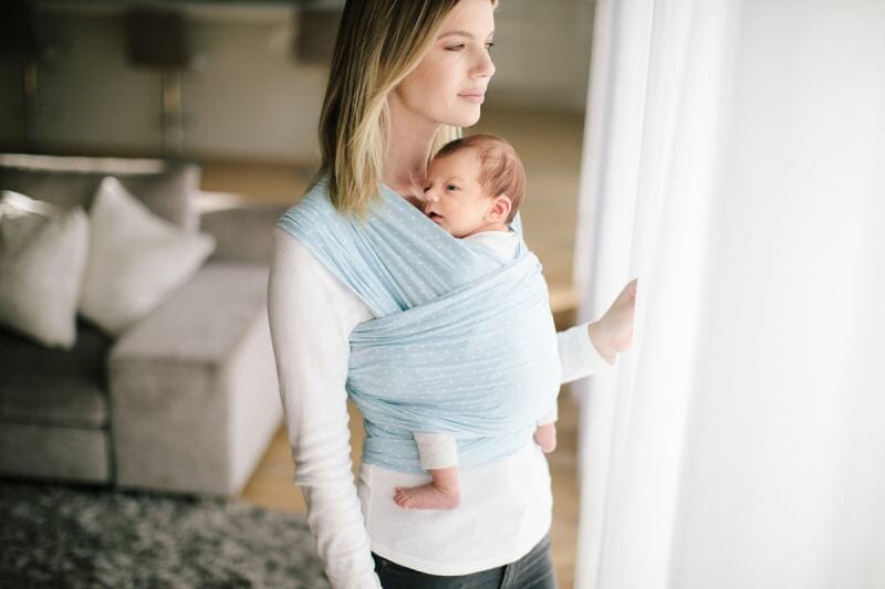 woman looking out window wearing her baby