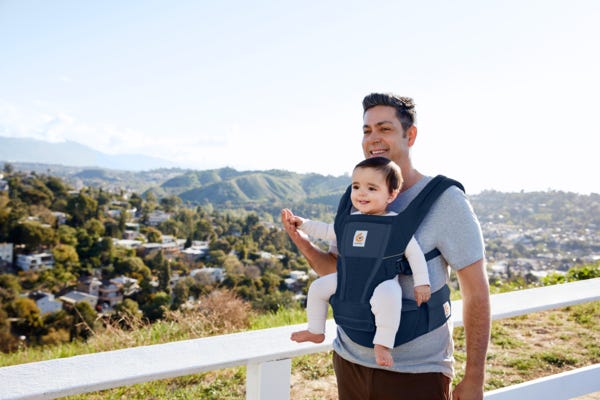 dad with child in a hip seat carrier 