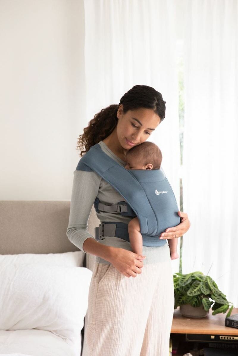 mom holding baby in ergobaby carrier